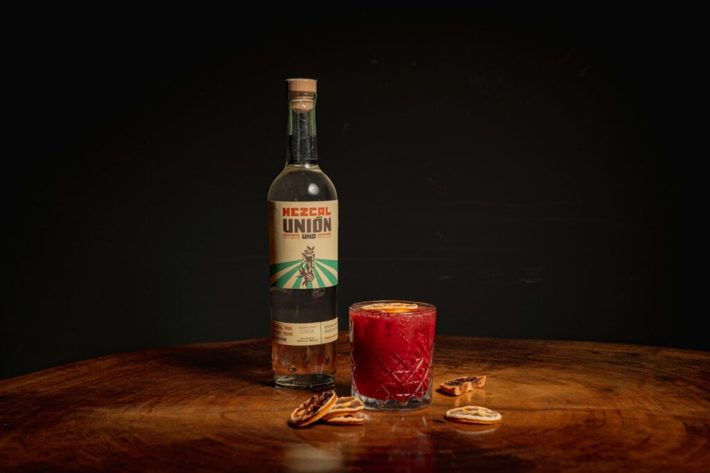 A bottle and a glass of liquid on a table