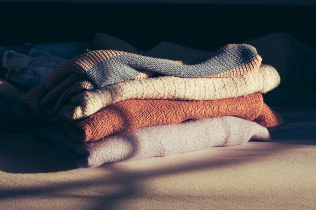 A pile of folded towels sitting on top of a bed