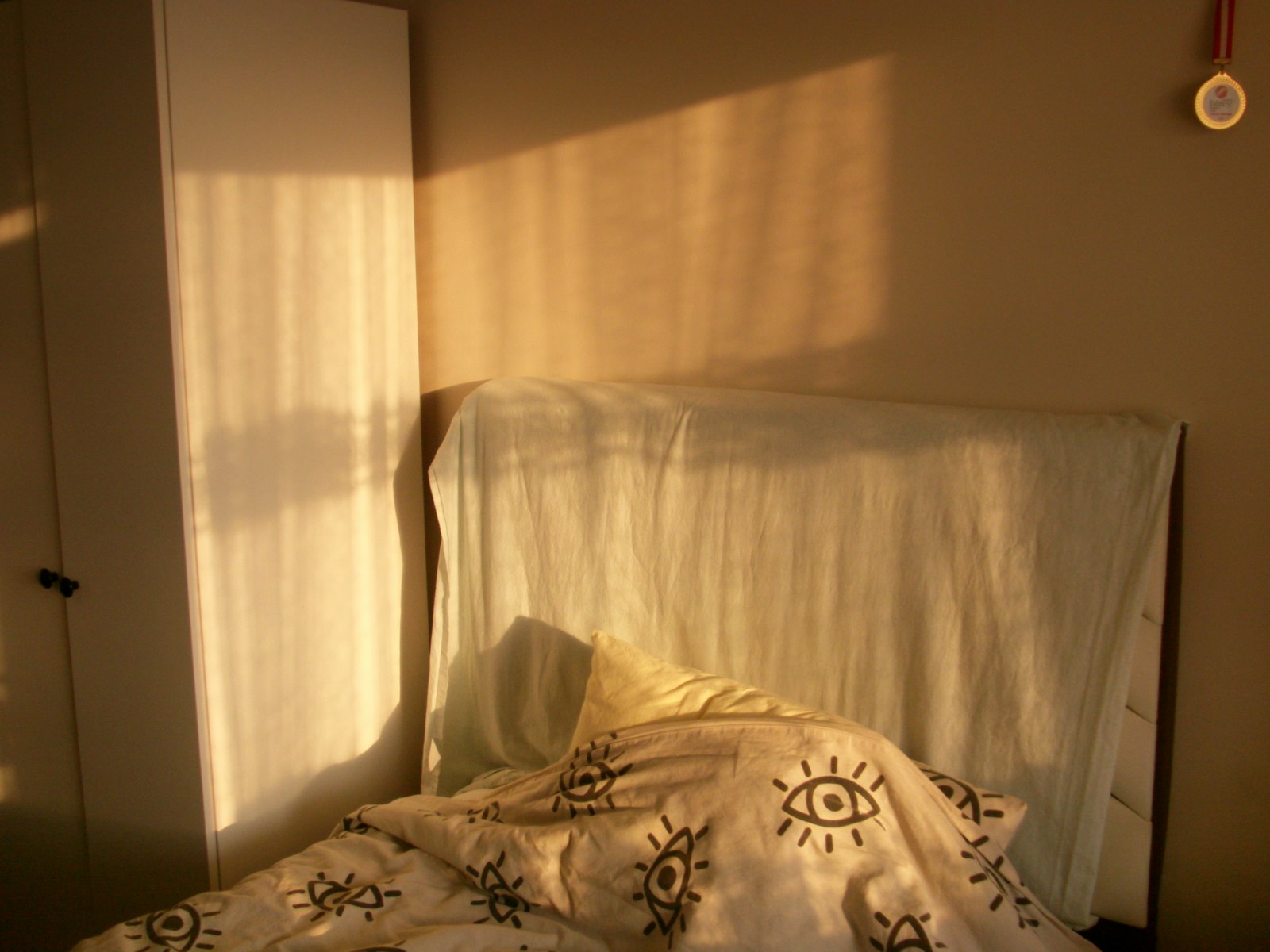 Warm sunlight streams into a bedroom with a bed