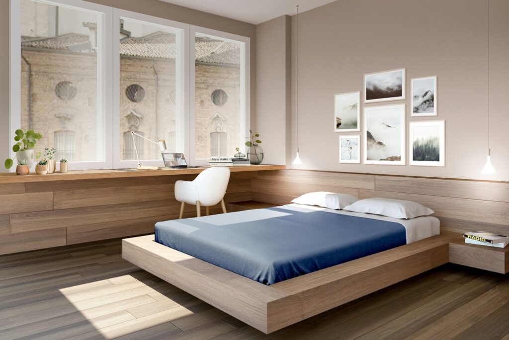 A bed room with a neatly made bed and a desk