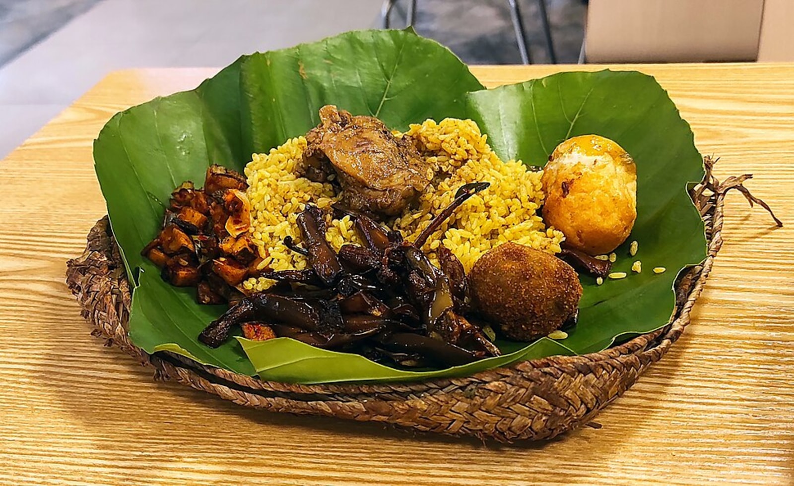 Yellow rice with meat and egg served on leaf