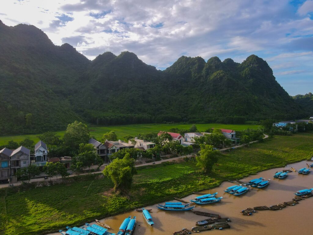 Boats docked on a river with mountains in background
