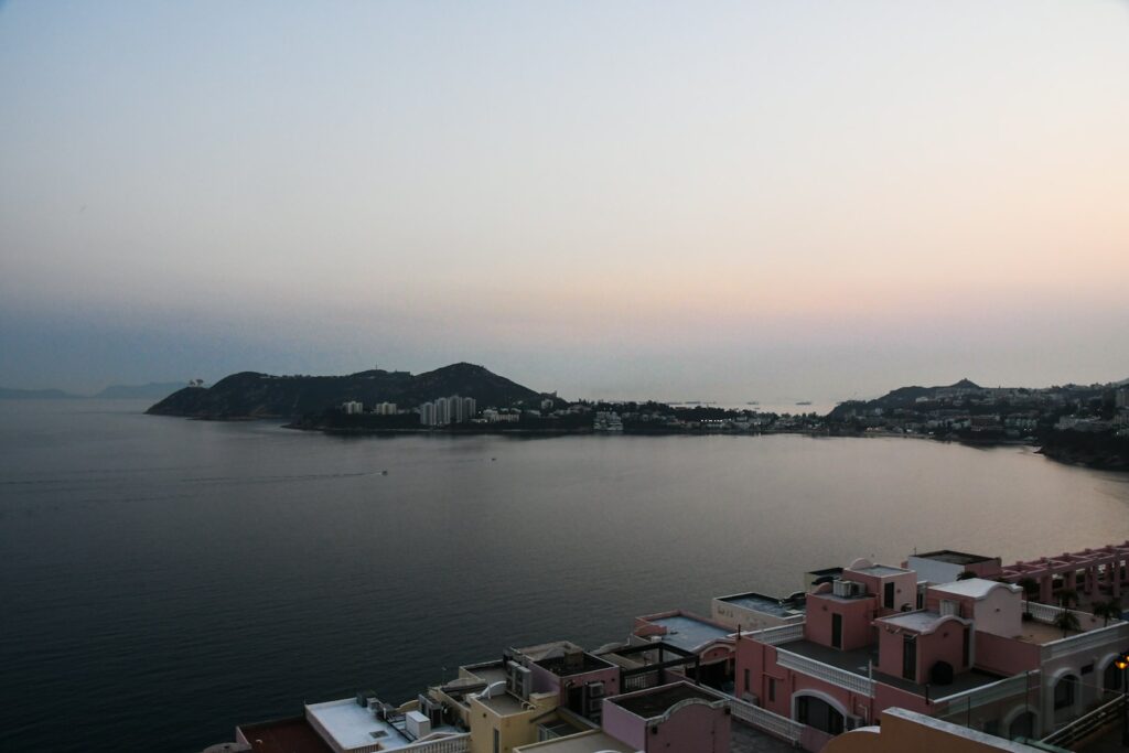 Coastal bay with distant hills and buildings at twilight