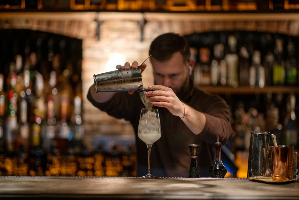A man is making a drink at a bar