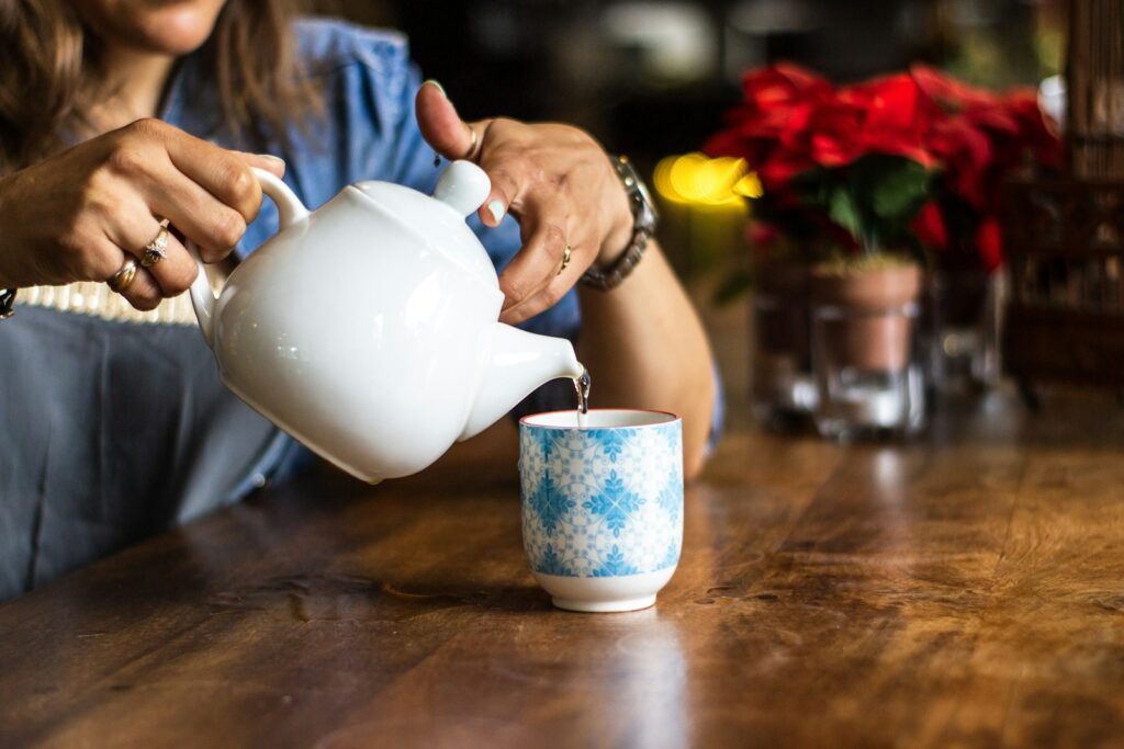 Unknown person holding white ceramic kettle