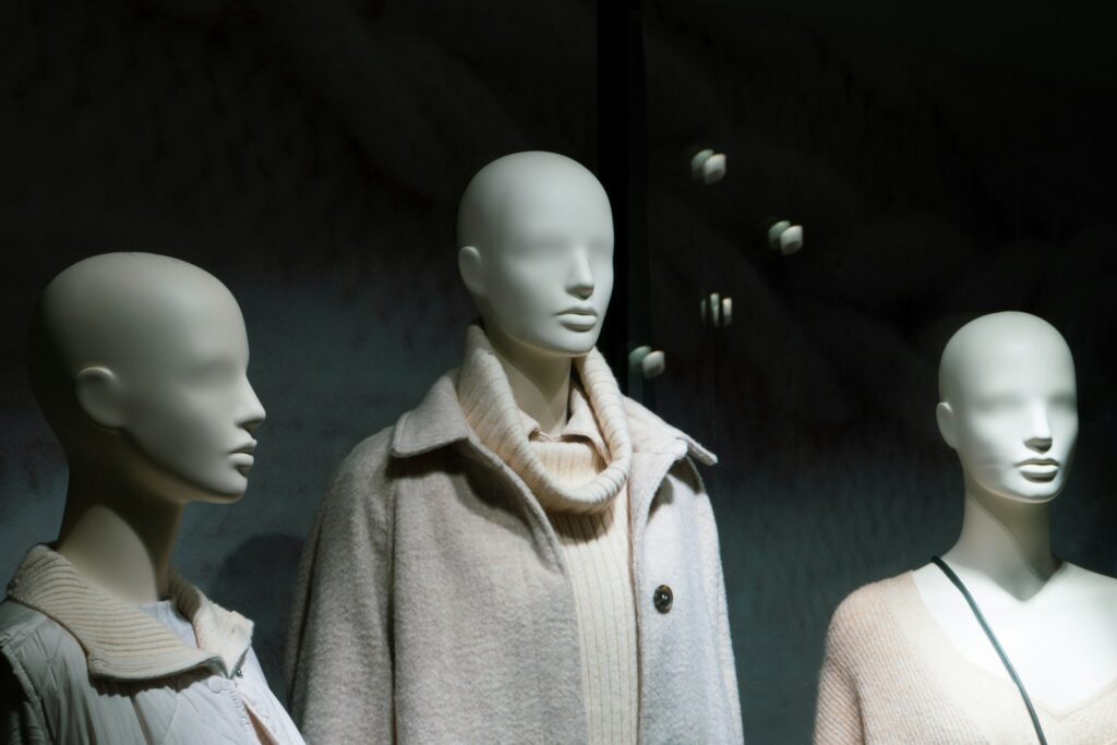 A group of mannequins wearing coats and scarves