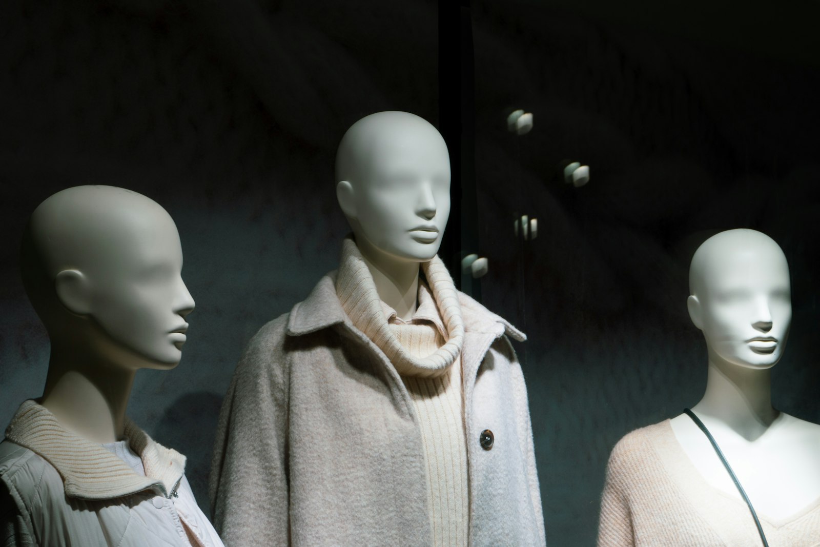 A group of mannequins wearing coats and scarves