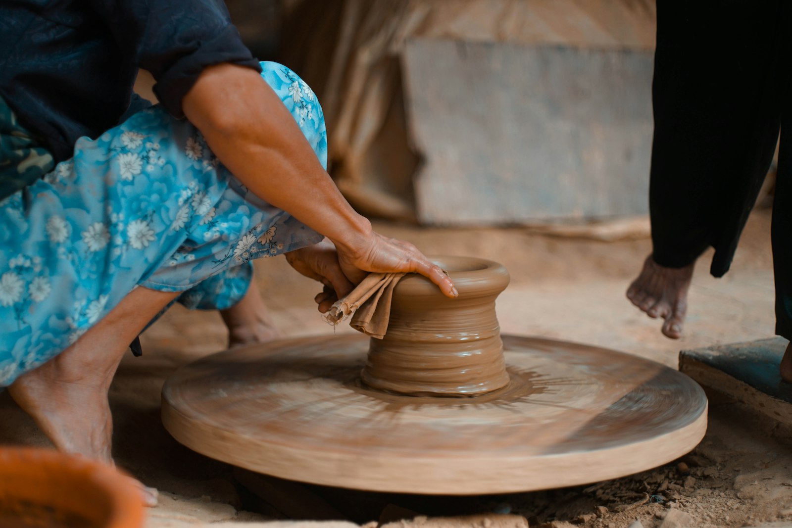 Person molding clay pot