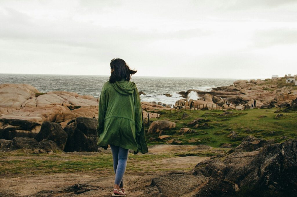 Woman walking near rocky shore