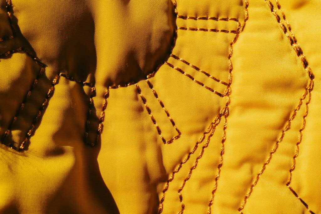 Close up of yellow fabric with stitched details