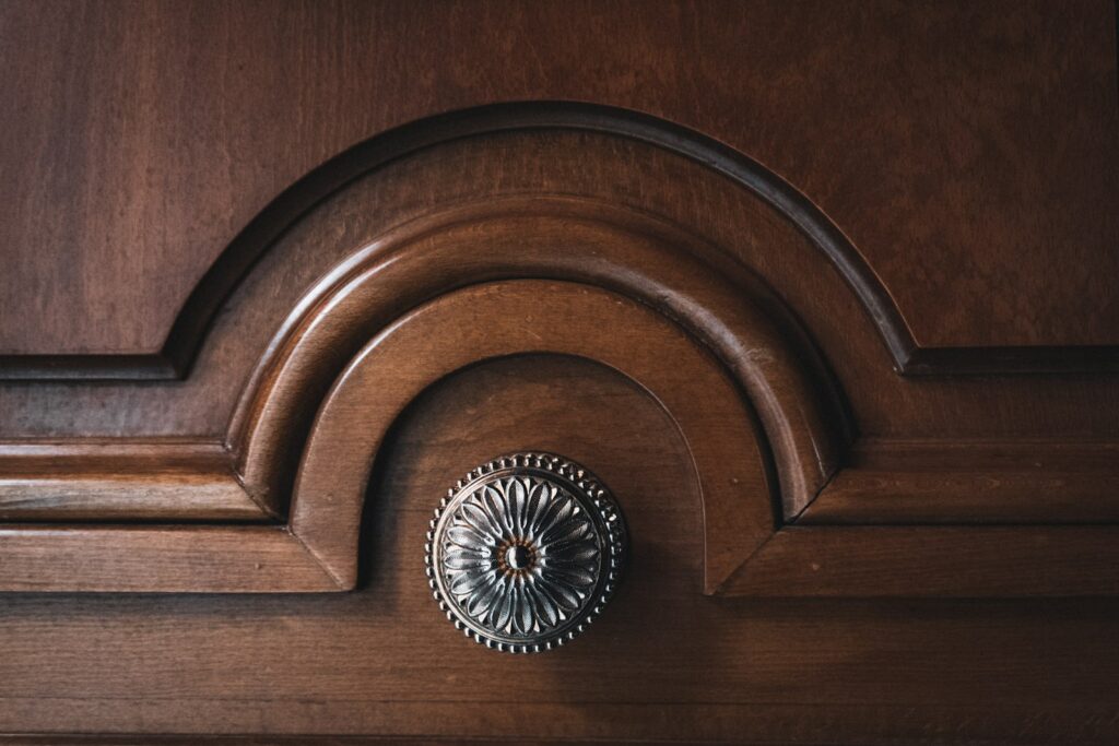 Dark wooden door with decorative carving and ornate metal knob