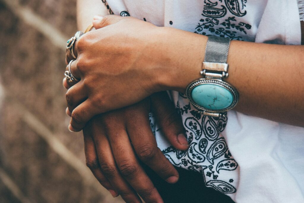 Person wearing silver link bracelet round analog watch