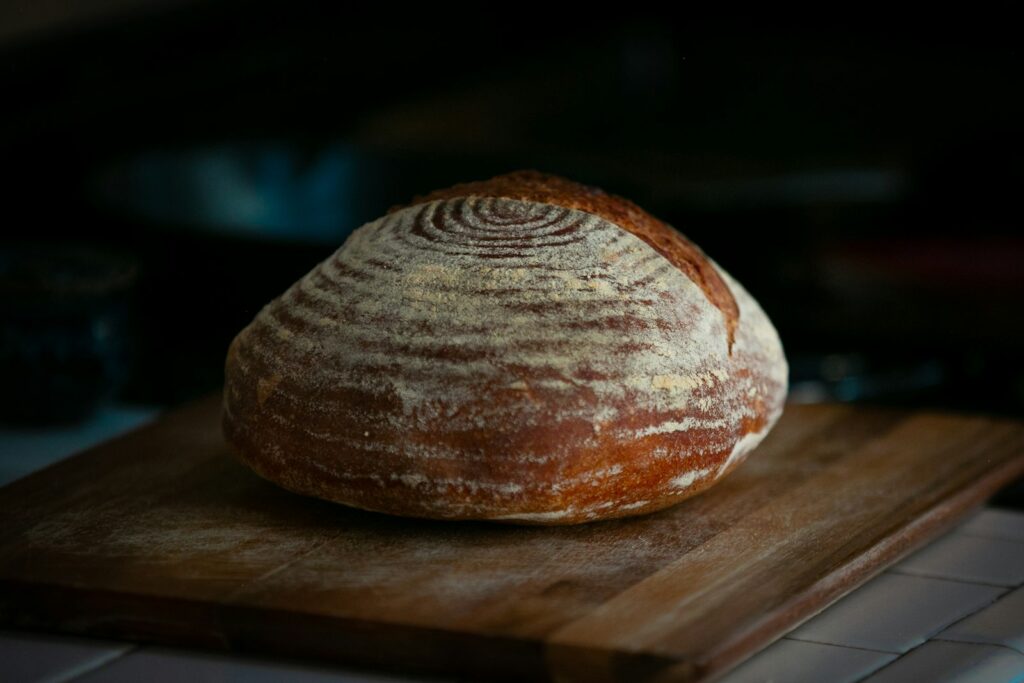 A rustic loaf of sourdough bread on a wooden board