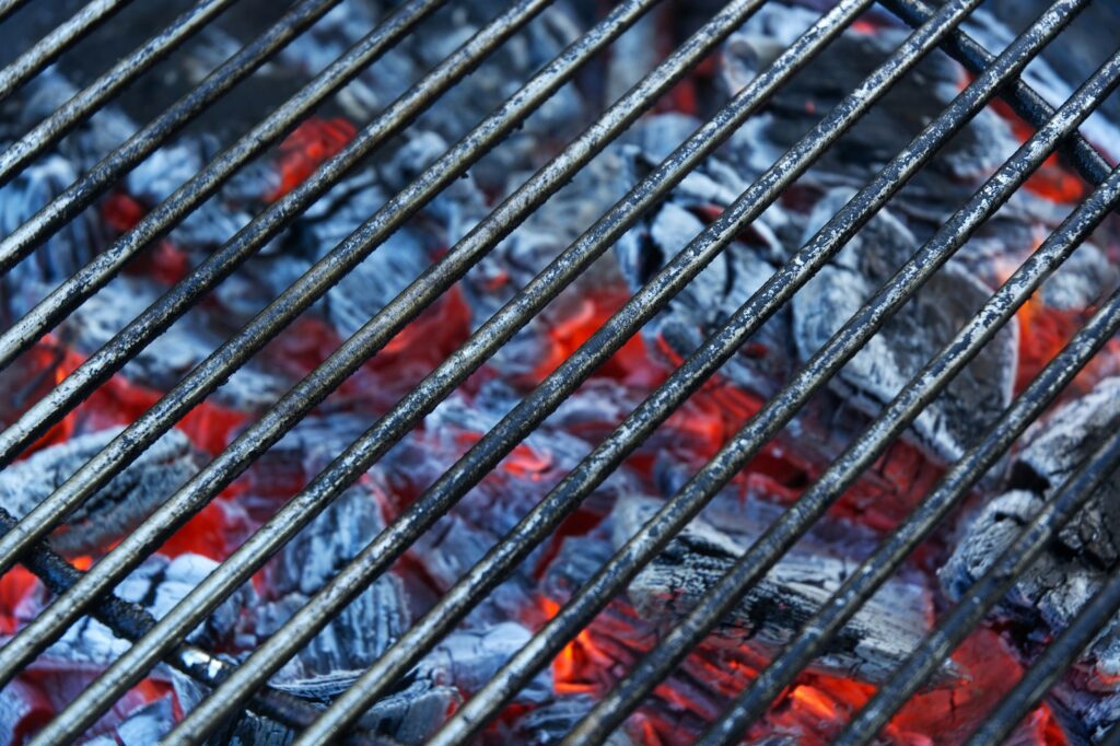 A charcoal grill grate with glowing embers