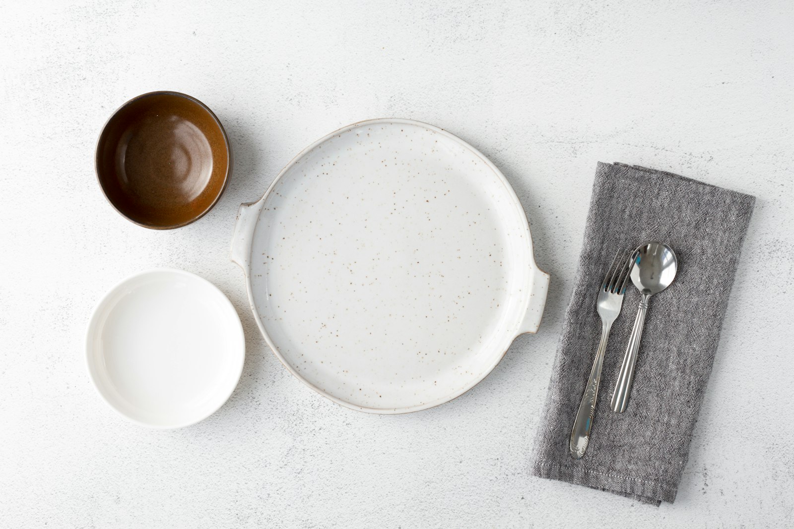 White ceramic plate beside stainless steel fork and bread knife