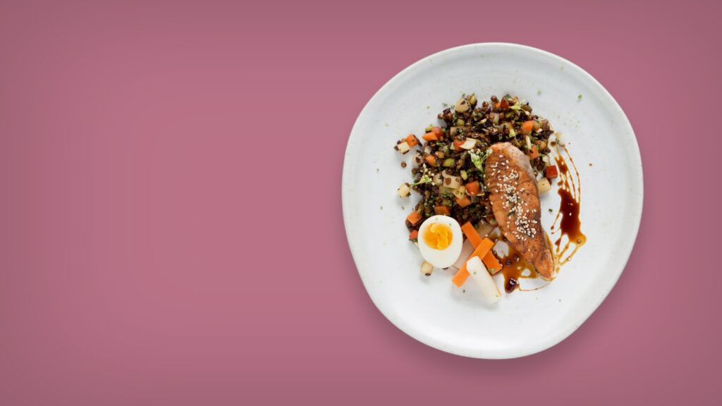 A white plate topped with meat and vegetables