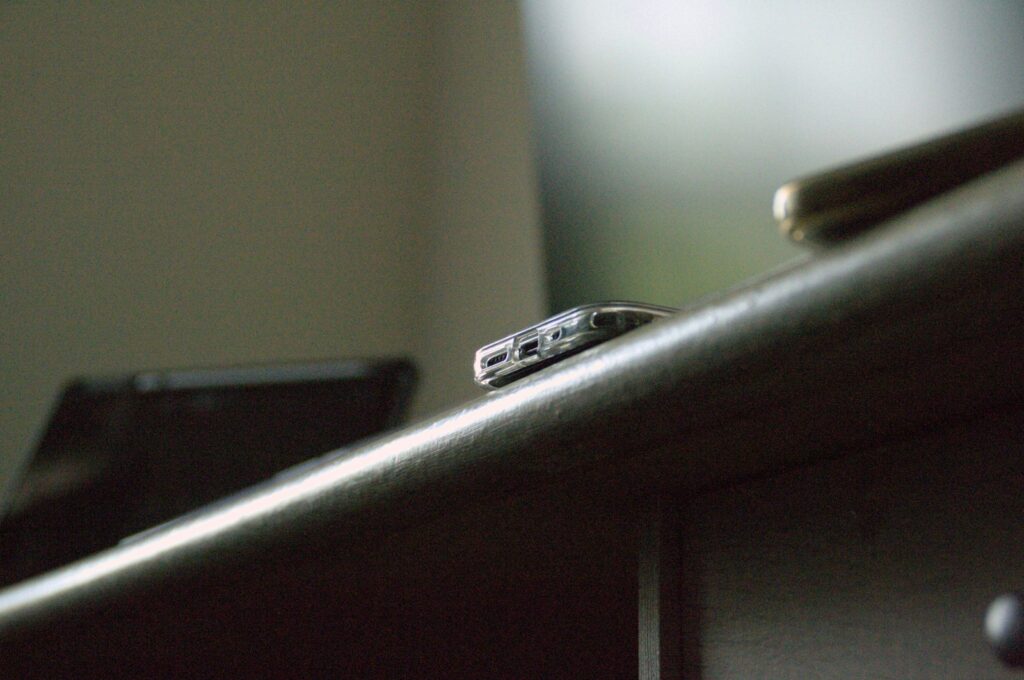 Phone and other items sit on a wooden surface