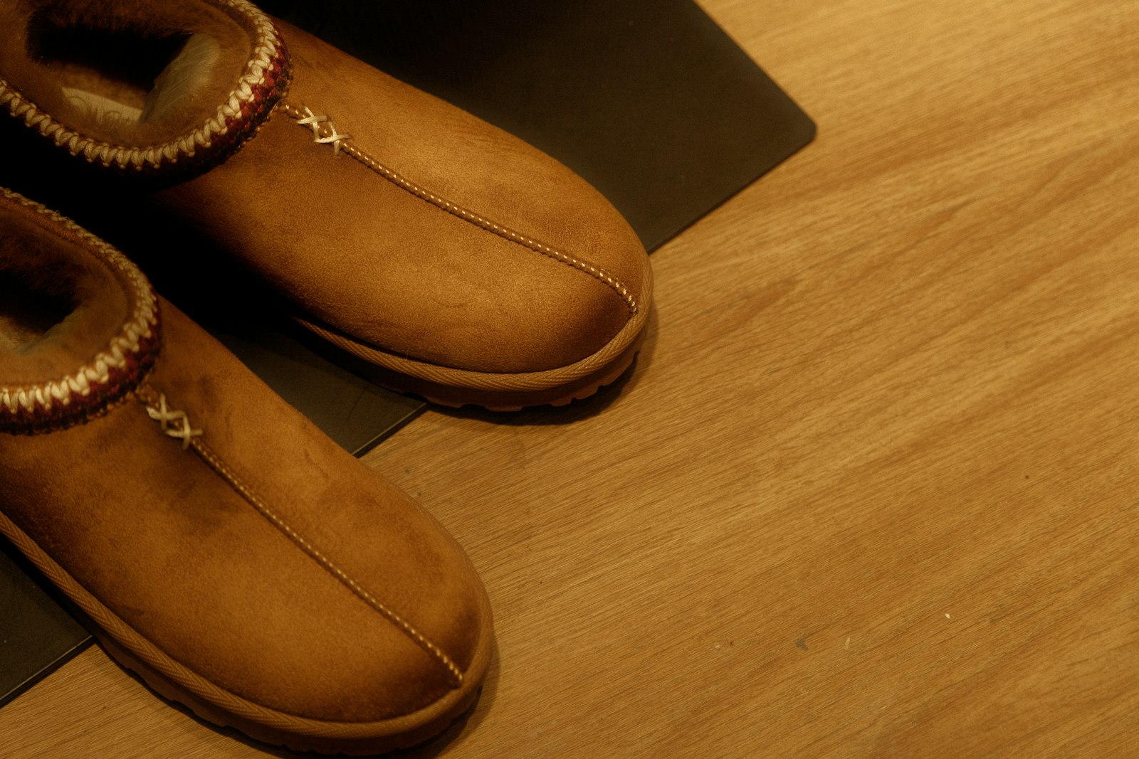 Cozy brown slippers on a wooden floor