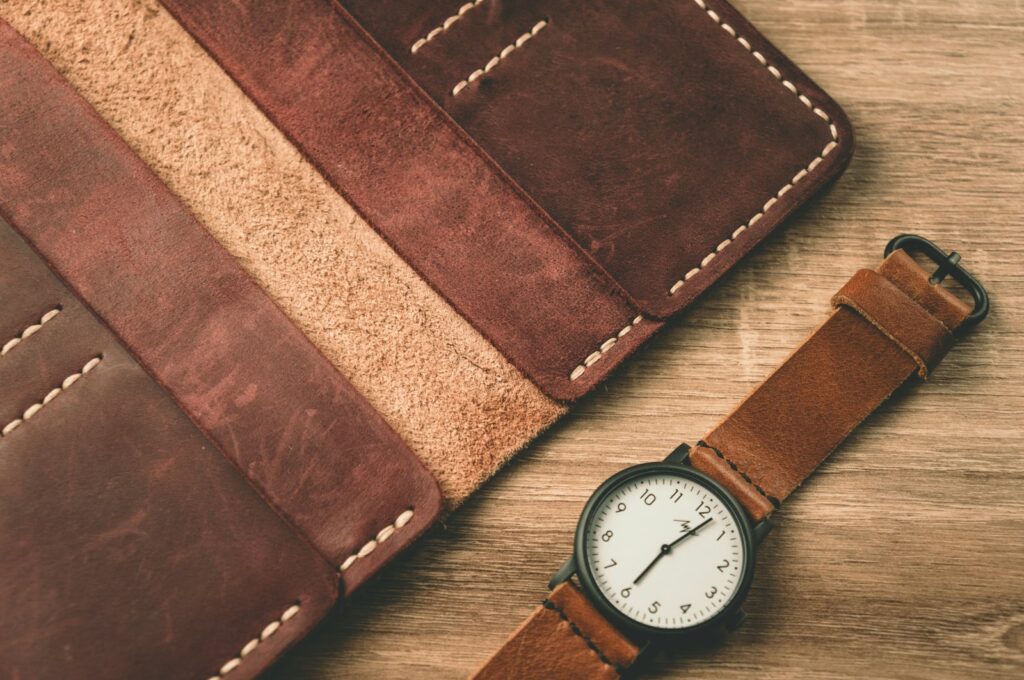 A watch sitting next to a wallet on a table