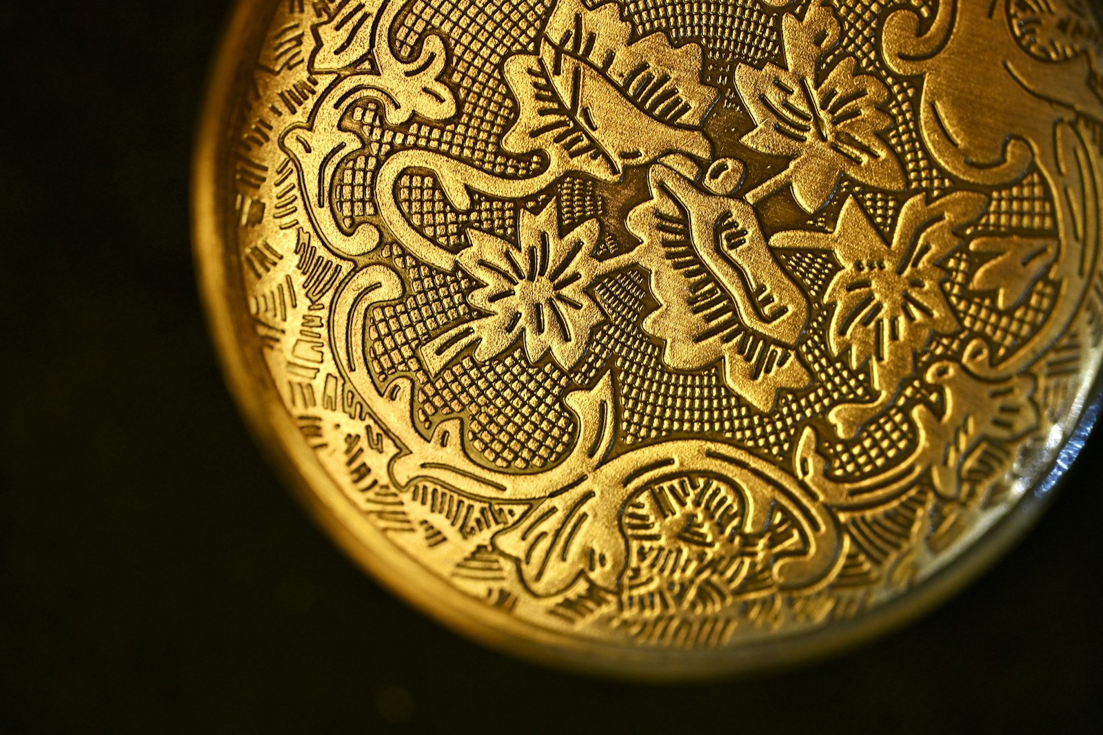 Close-up of ornate gold pocket watch engraving