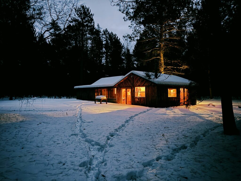 Cozy cabin glowing in the snowy woods at night