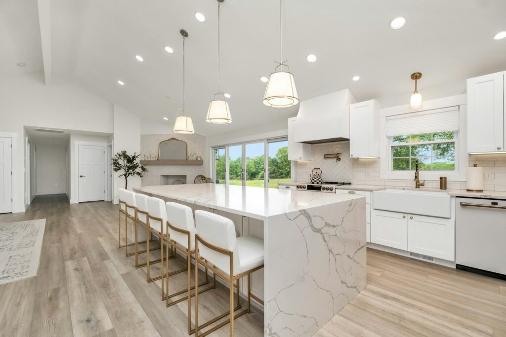 A large kitchen with a marble island and white cabinets
