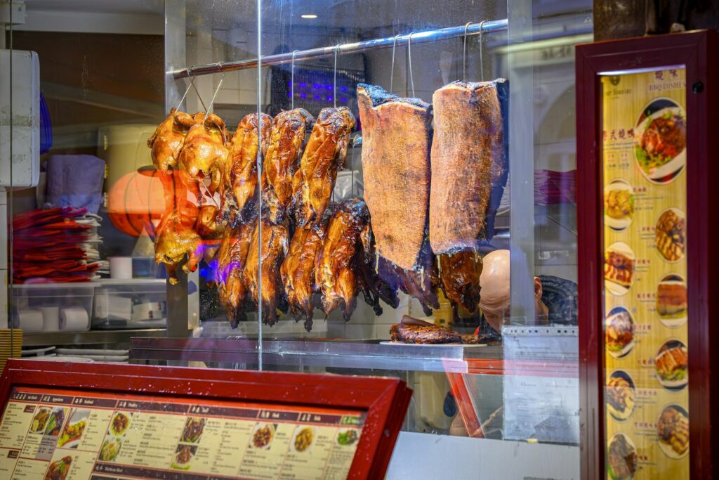 Roasted ducks and pork hanging in a food stall
