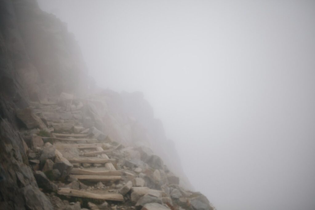 A foggy mountain side with stairs and rocks