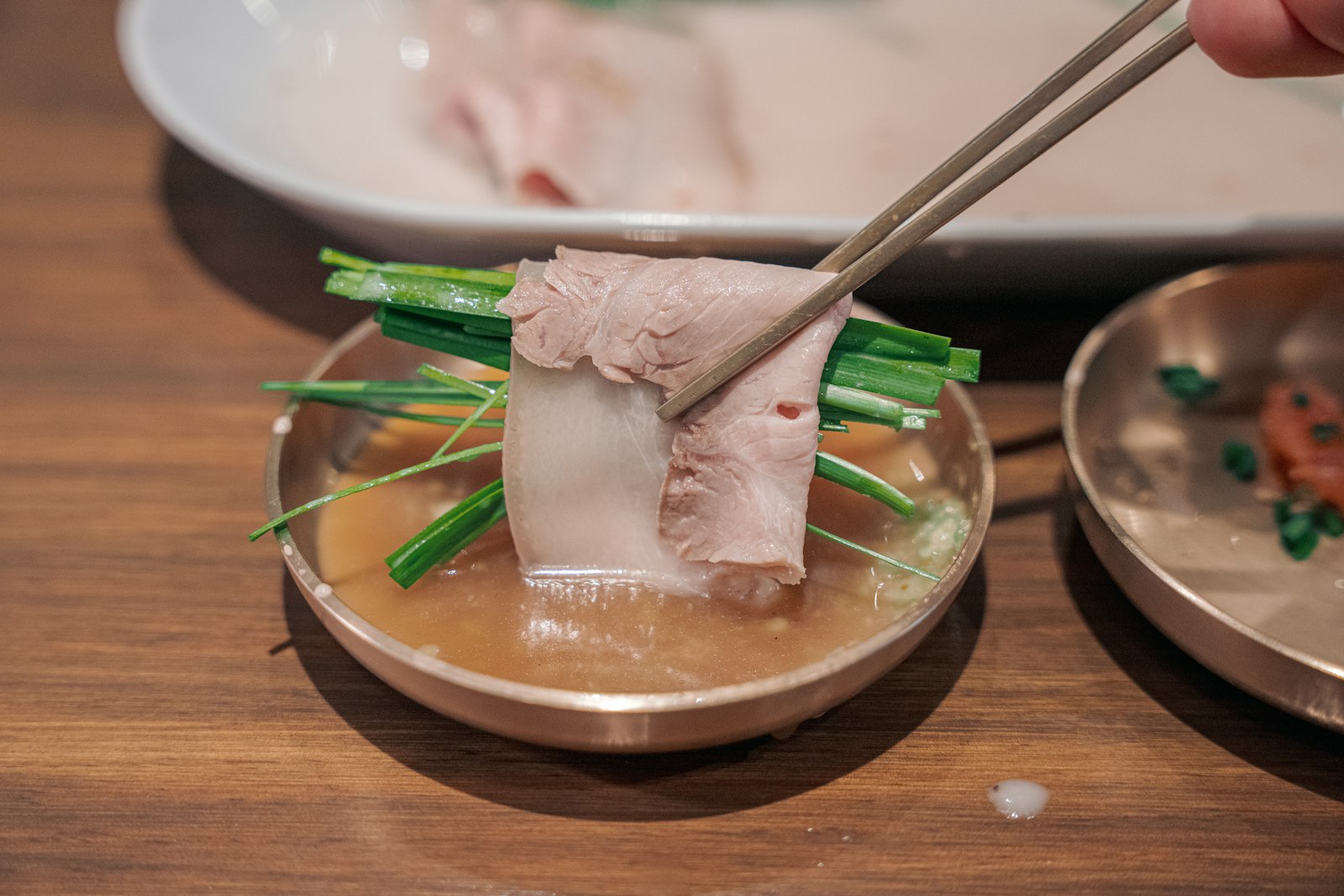 A person holding chopsticks over a plate of food