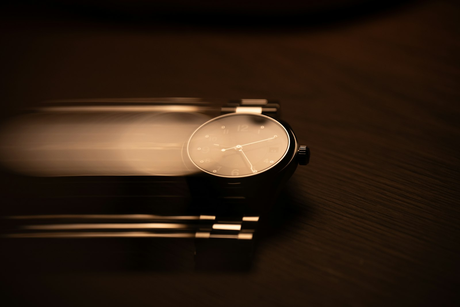 A watch with motion blur on a dark surface