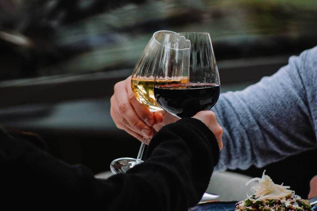 A couple of people holding hands over a glass of wine