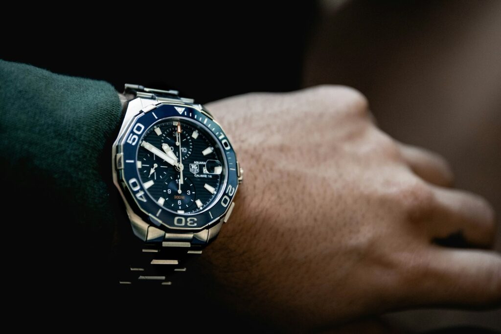 Round black chronograph watch at 5:50