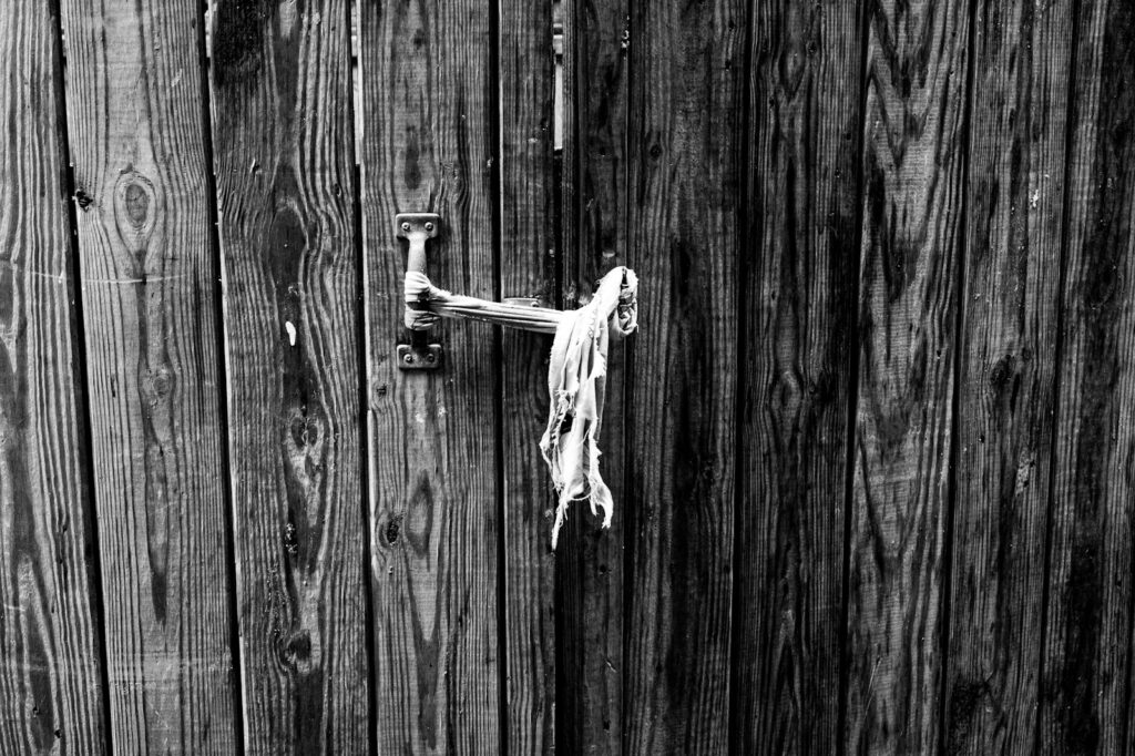 Old wooden fence with a metal handle and rope