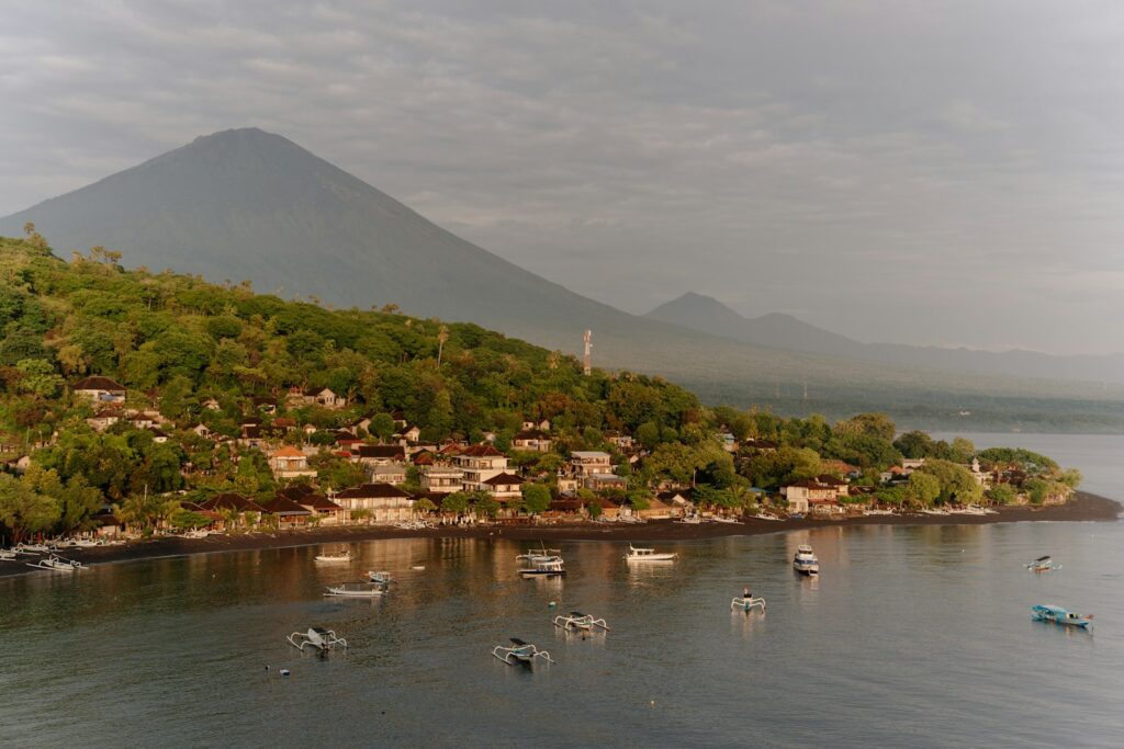 Boats in tropical bay with distant volcano