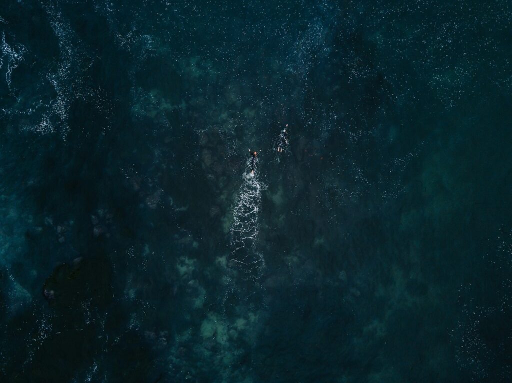 Bird's eye photography of two person swimming in ocean