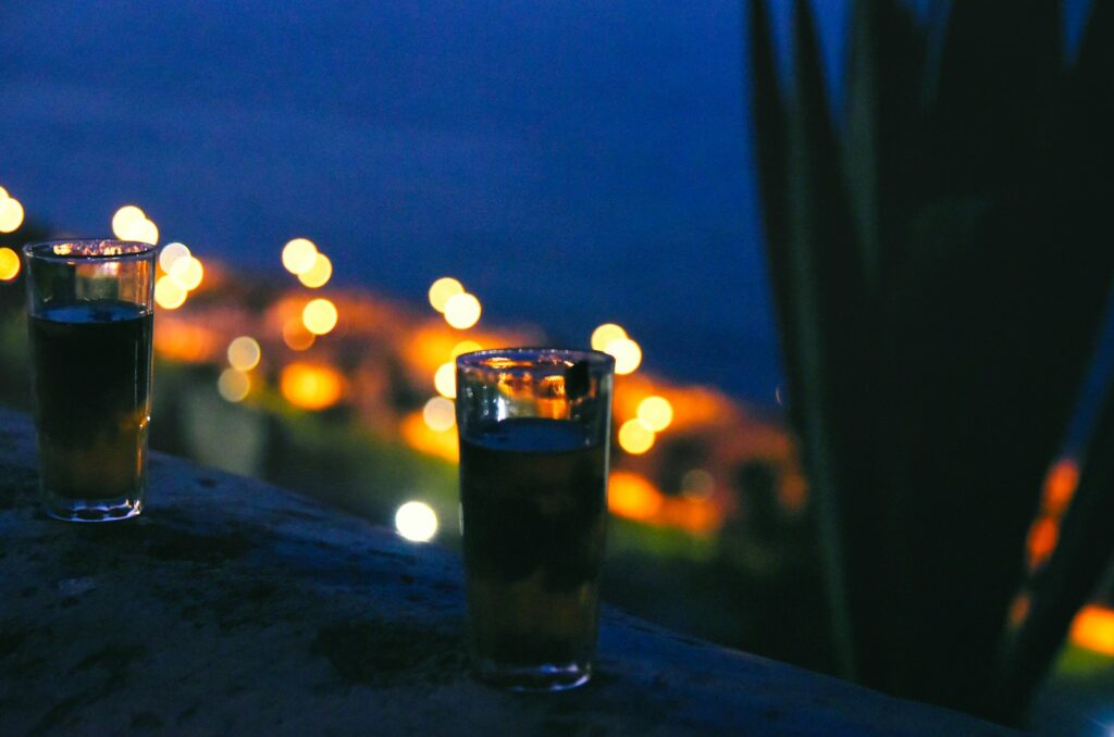 Three glasses of beer with city lights background