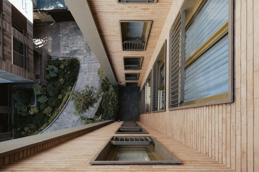 Looking down a tall building with windows and a courtyard