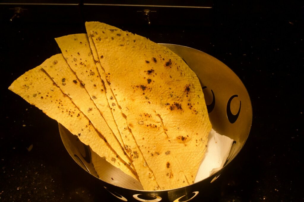 A metal bowl filled with tortillas on top of a counter