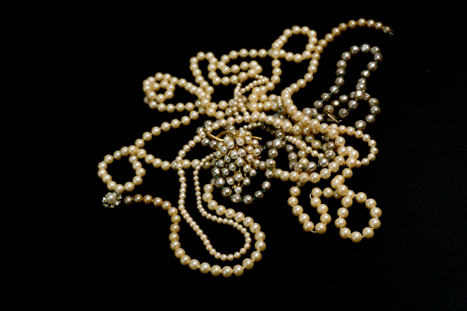 A close up of a necklace on a black background