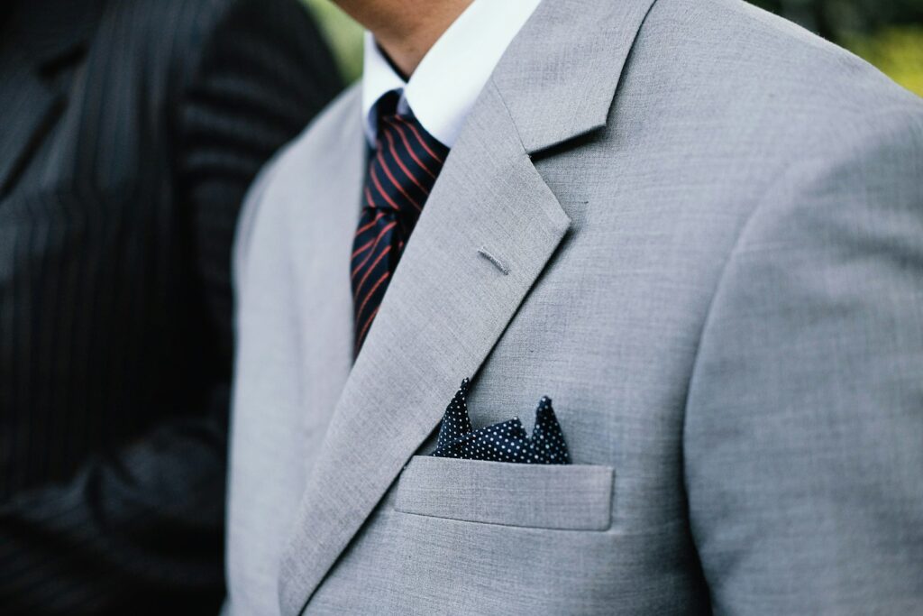 Man wearing gray notched lapel suit jacket standing