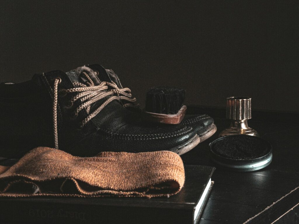 Brown suede boots beside silver iphone 6 on brown wooden table