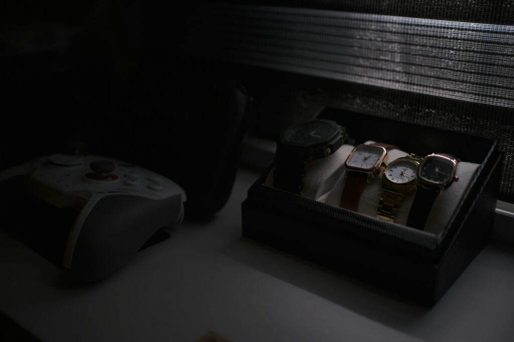 Four watches in a display box near a controller