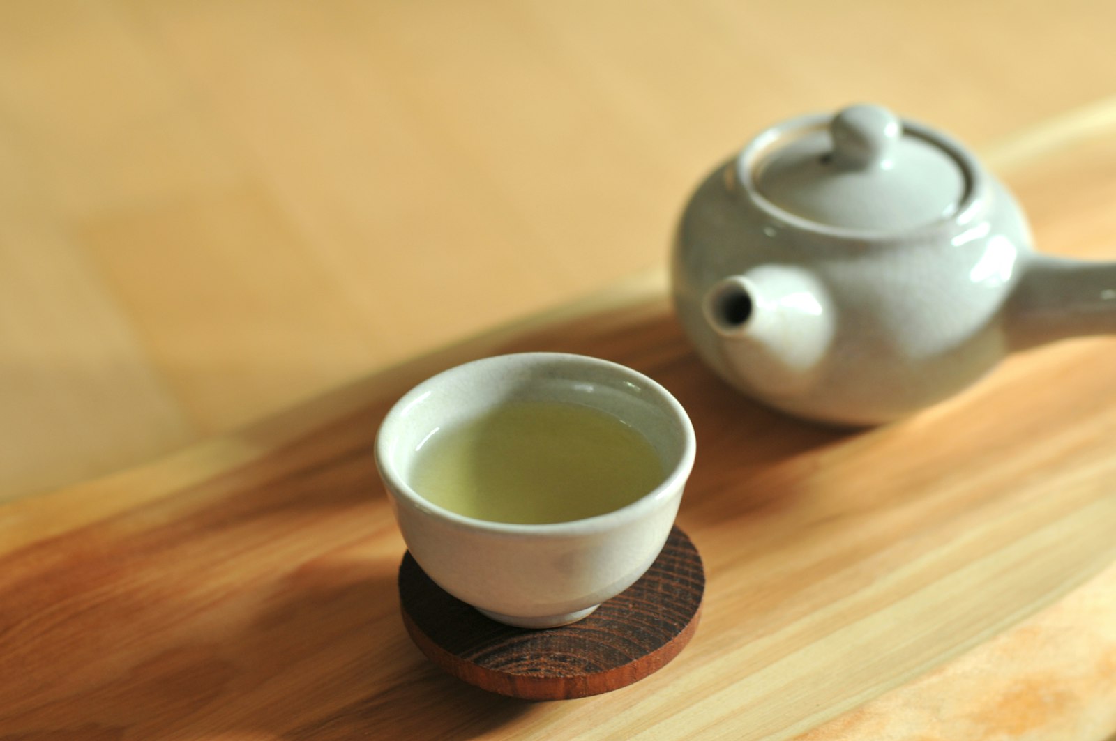 White ceramic teacup on brown wooden table