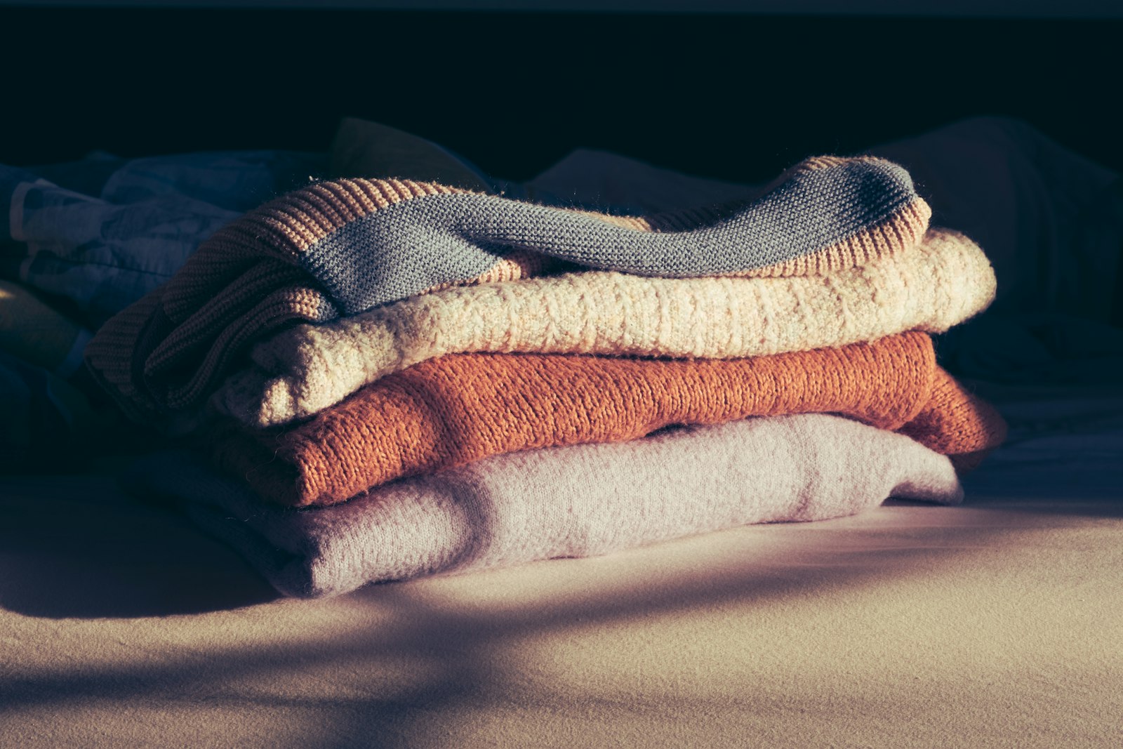 A pile of folded towels sitting on top of a bed