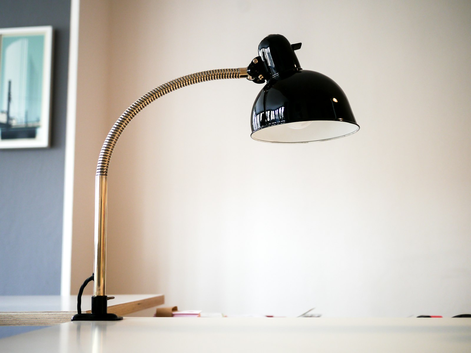 A desk lamp sitting on top of a wooden desk