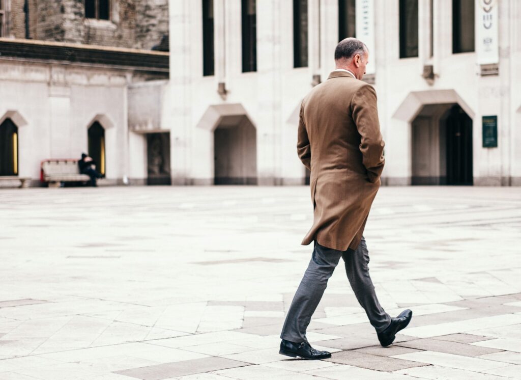 Man walking in front of white building