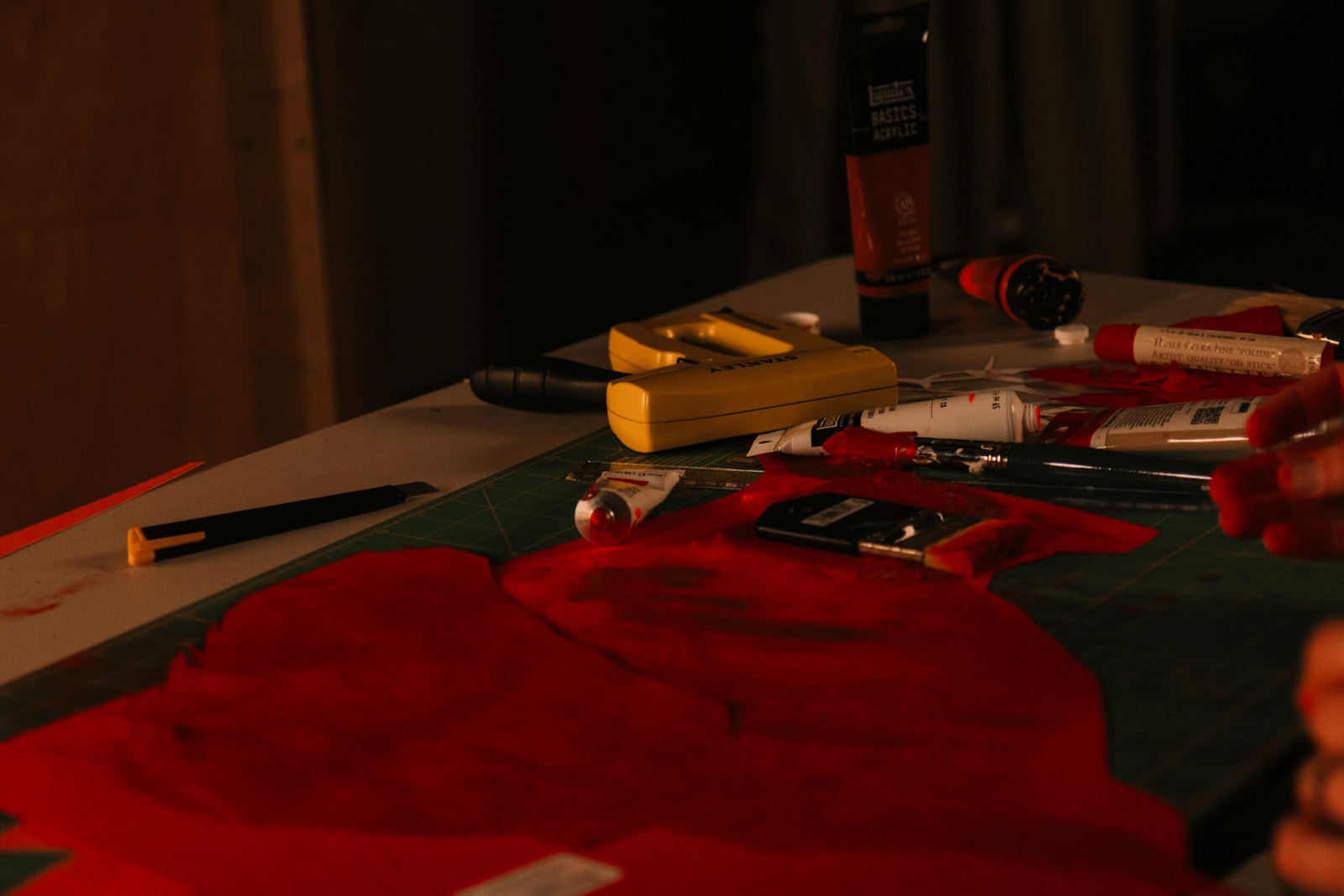 Artist's table with red paint and brushes