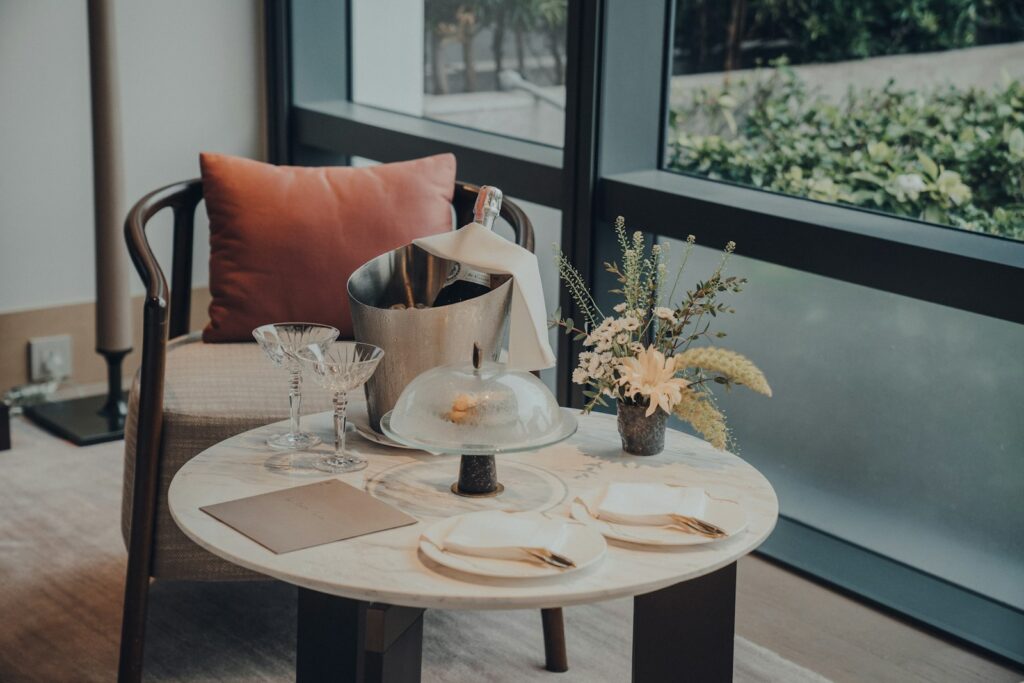 A table with a vase of flowers and plates on it