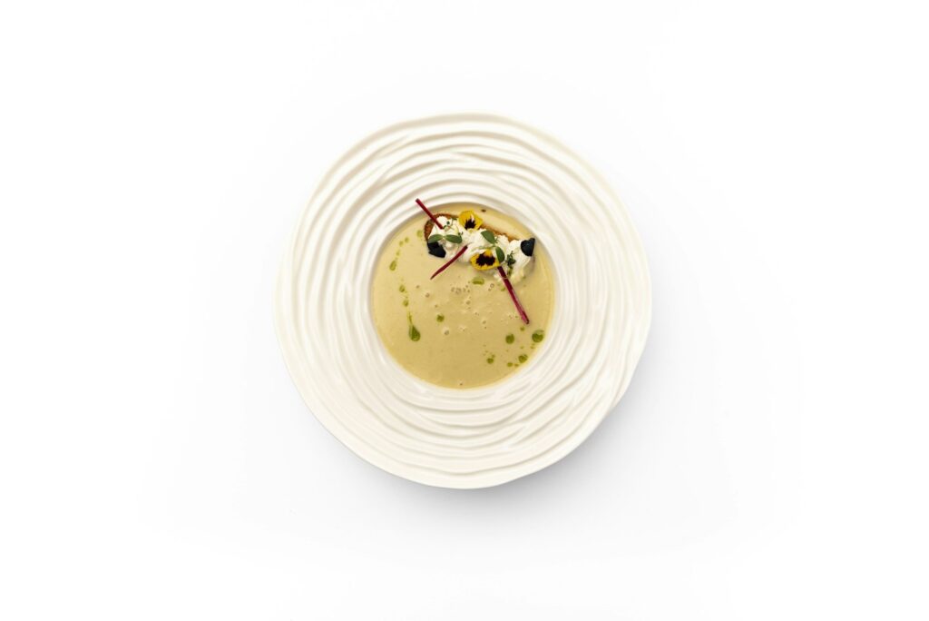 Gourmet soup with delicate garnish in a textured bowl