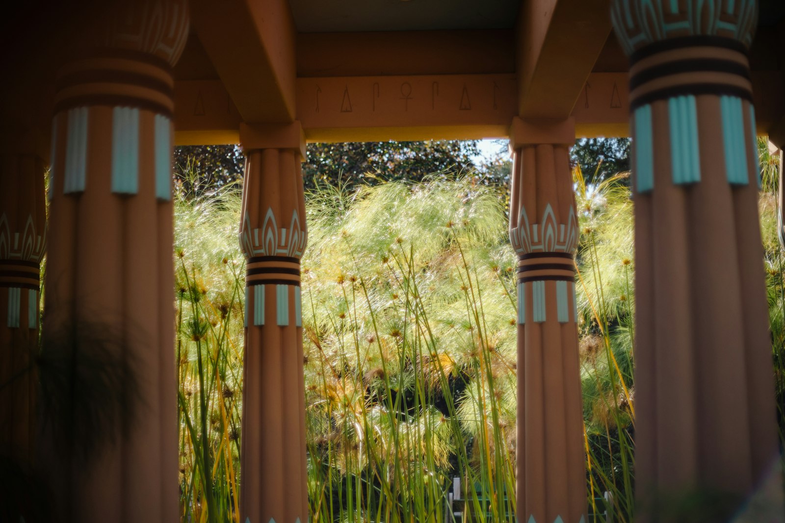 Egyptian columns in front of tall green plants
